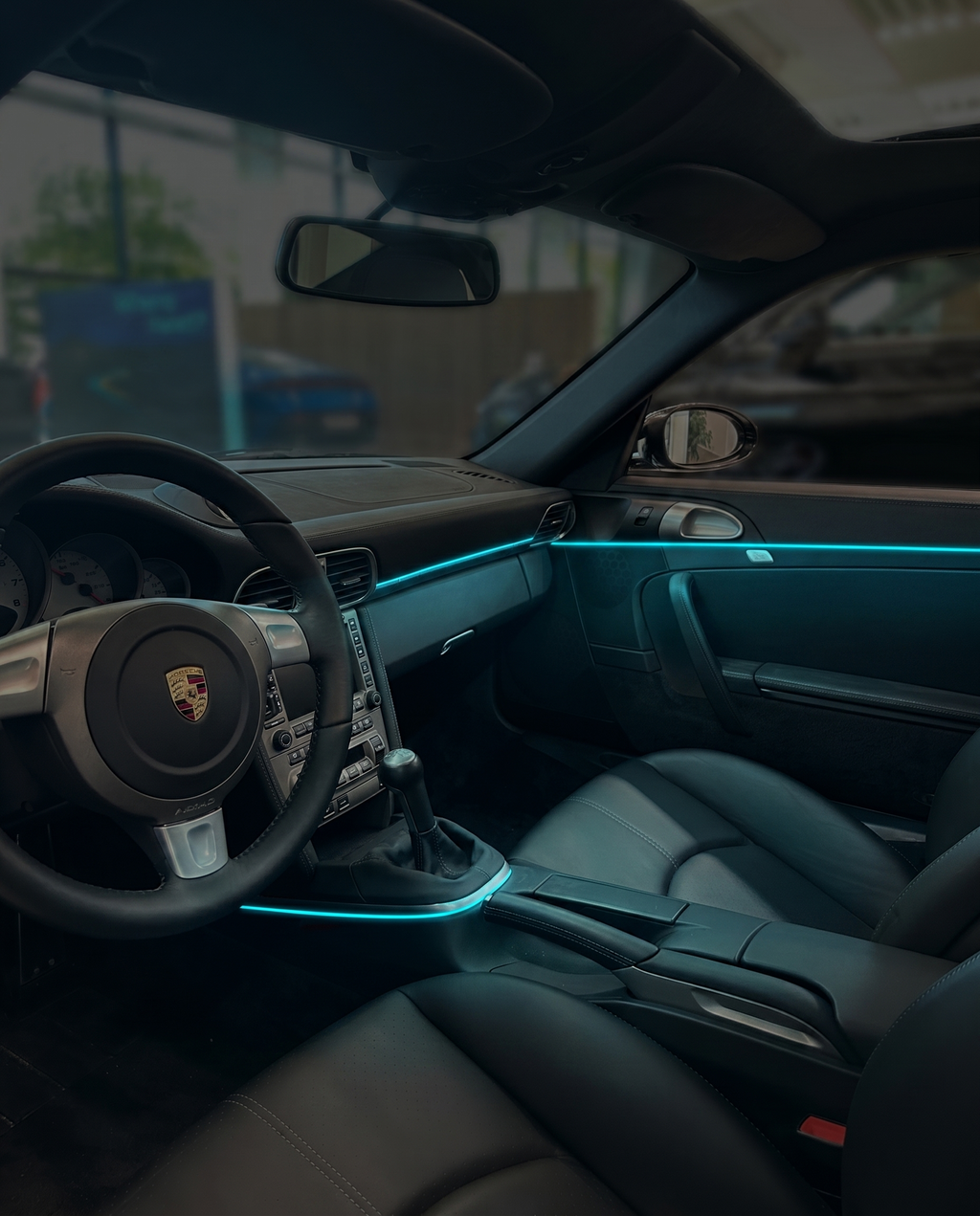 VYNTRA cyan ambient light glowing in a sporty black car interior at night